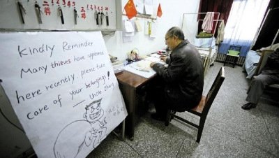 張大爺在門(mén)衛(wèi)室里工作，旁邊是紅爆網(wǎng)絡(luò)的溫馨提示牌記者