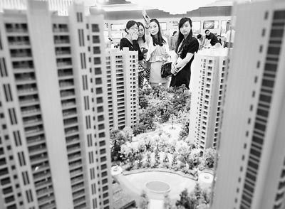 圖為近日，浙江杭州一家房產(chǎn)公司的兩位銷(xiāo)售人員一起向購(gòu)房者介紹樓盤(pán)。新華社記者 王定昶攝