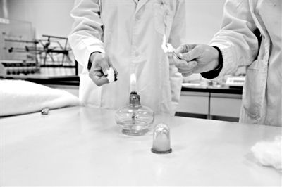 實驗人員操作的燃燒檢測法中，真蠶絲離開火焰就熄滅(左)。