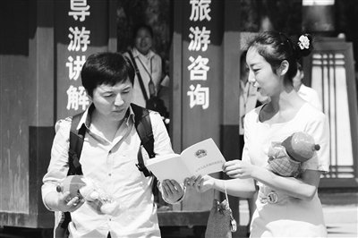 9月13日，西安臨潼華清池景區(qū)服務(wù)人員向游客介紹《旅游法》。