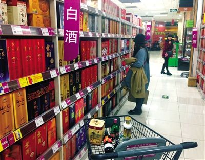 顧客在商場(chǎng)的高檔白酒貨架前駐足挑選。春節(jié)臨近，受“禁令”影響，以高檔白酒為代表的節(jié)日禮品市場(chǎng)面臨考驗(yàn)。記者 王遠(yuǎn)征 攝