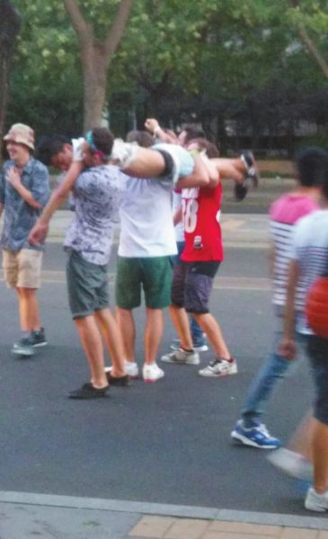 　四名外籍男子一同扛起醉漢拍照。