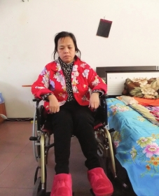 陳慶霞坐在輪椅上。她現(xiàn)在下身癱瘓，疾病纏身，生活不能自理。