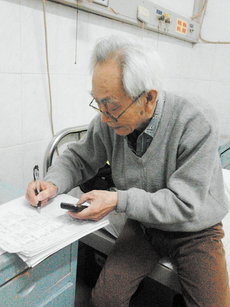 杜修源老人埋頭寫著特殊的“日記”。 李卓 攝