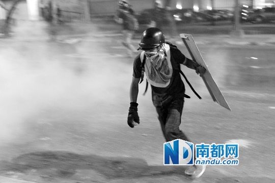 反政府示威者在與警察的沖突中躲避催淚彈。