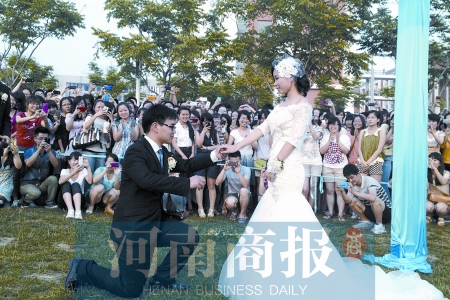 在學(xué)校操場的草坪上，兩名畢業(yè)生舉行婚禮，有同學(xué)感動(dòng)地抹起眼淚