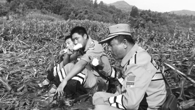 饑餓難忍，中國(guó)緊急救援河南基地的救援隊(duì)員在已毀的玉米地里撿拾生玉米吃。