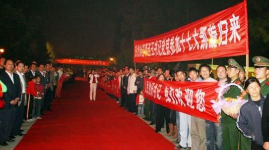 “夾道歡迎”中不少人打出橫幅，路上被鋪上了紅毯。