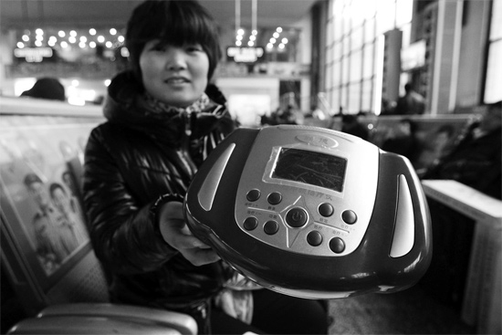 火車站候車室，李女士向記者展示她準(zhǔn)備孝敬父母的按摩儀