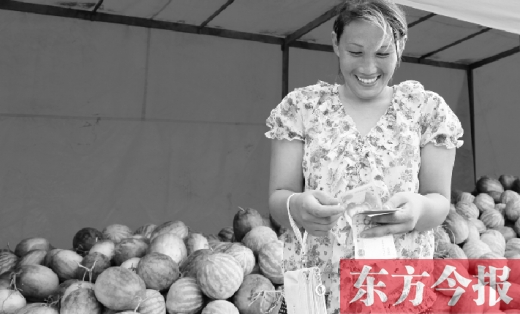 昨日，開封瓜農(nóng)史瑩瑩幸福地?cái)?shù)著賣瓜錢 東方今報(bào)記者 沈翔 攝