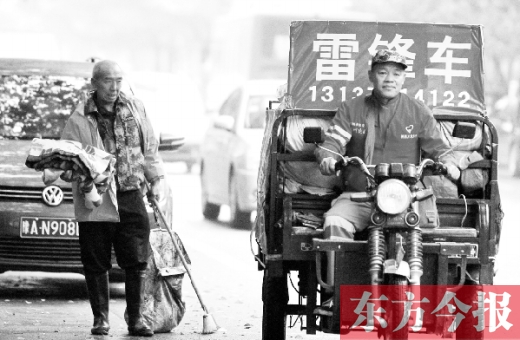 鄭州市商城路，一名環(huán)衛(wèi)工懷抱著剛剛收到的毯子，目送“雷鋒哥”孫德坤離開(kāi)