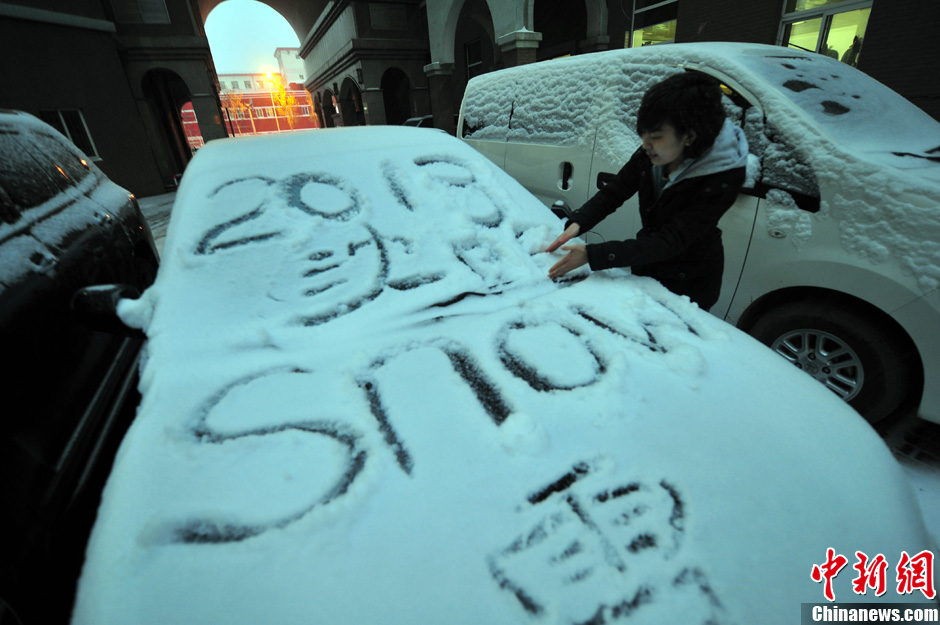 11月18日，行人在車輛的積雪上涂鴉。