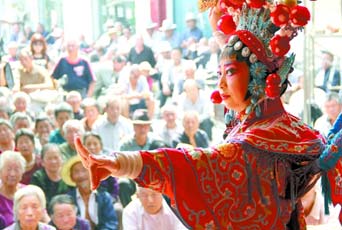 圖為8月15日戲曲演員在“流動(dòng)舞臺(tái)車”上表演傳統(tǒng)地方戲《穆桂英下山》。