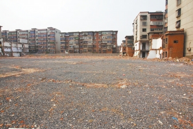 為降塵，旮旯王村拆遷后裸露的地面上鋪了一層石子。