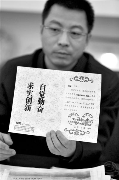 昨日，首師大美術(shù)學(xué)院黨委書(shū)記出示被騙學(xué)生的錄取通知書(shū)，表示“本科”字樣是由招生公司虛假宣傳、擅自添加。新京報(bào)記者 浦峰 攝