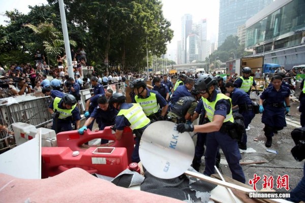 10月14日，警方清除金鐘道障礙物。大批警員在金鐘道現(xiàn)場(chǎng)清拆障礙物。部分警員戴上頭盔將障礙物移走。