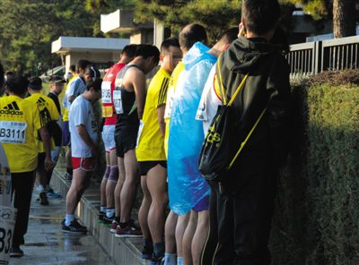 2013年10月20日，北京馬拉松比賽，由于廁位有限，一些選手在綠化帶“就地解決”。圖/IC