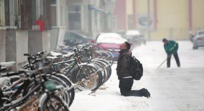小伙子跪在樓前，一直抬頭看著樓上。 孫立國/攝