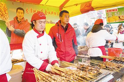 賣羊肉串?dāng)偽焕习遐w山（穿紅衣者）。新京報(bào)記者