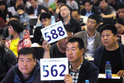 昨日，拍賣現(xiàn)場競拍者舉牌競拍。新京報記者