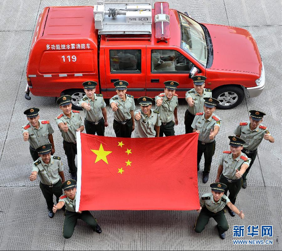  9月25日，武警浙江嘉興消防官兵與國(guó)旗合影。