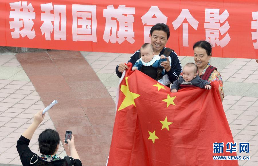 9月27日，在山東德州市中心廣場(chǎng)，市民與國(guó)旗合影。