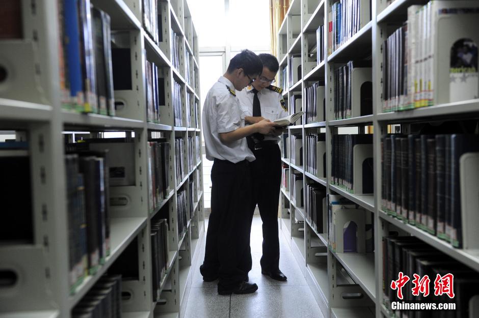 5月8日，武漢輕工大學保安吳濤與江力在圖書館交流學習。中新社發(fā) 張暢 攝