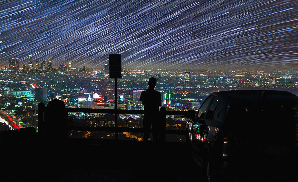 照片中，一名男子看著流星和隕星劃過天空。（網(wǎng)頁截圖）