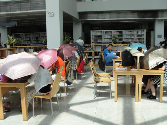 圖書館內(nèi)撐傘讀書的民眾。