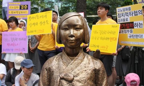 7月2日，在韓國首爾的日本駐韓國大使館前，民眾在慰安婦少女像旁手持標(biāo)語參加抗議活動。