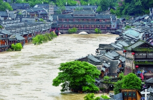 7月16日,沱江兩邊的商鋪和遠(yuǎn)處的虹橋仍淹沒在洪水中。 新華社發(fā)