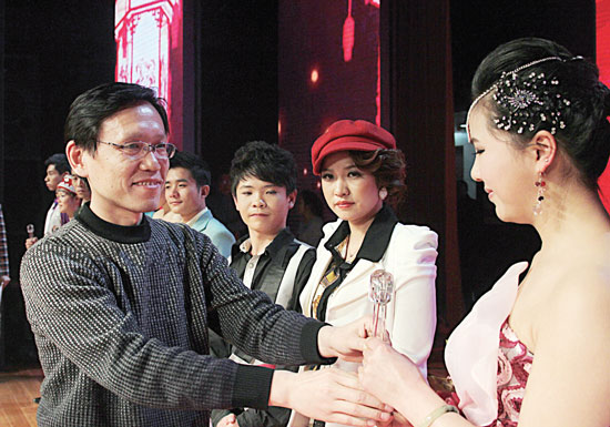 2013年2月1日，《對9當(dāng)歌》總決賽在鄭州開唱。圖為東方今報(bào)副社長胡楊為選手頒獎(jiǎng)