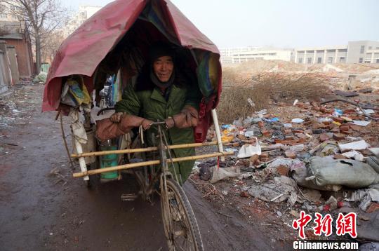 圖為老人走出窩棚，推著三輪車準備出去撿拾廢品。周小云 攝